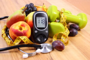 Healthy lifestyle concept with fruits, glucometer, and dumbbells
